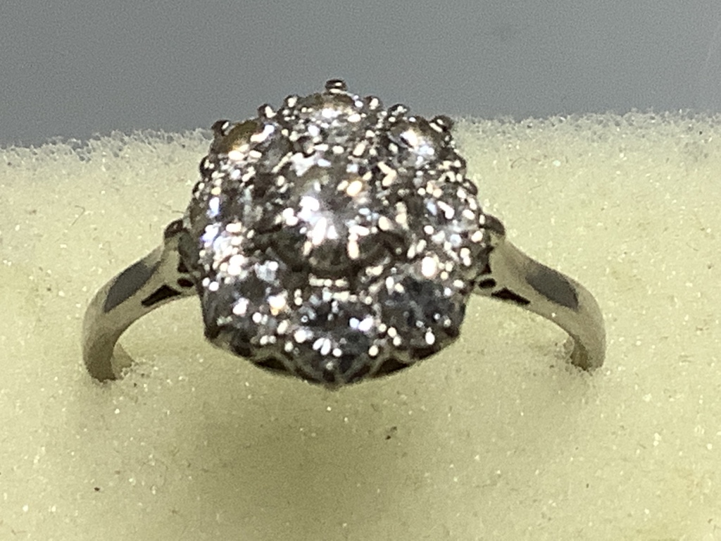 A platinum and nine stone diamond circular cluster ring